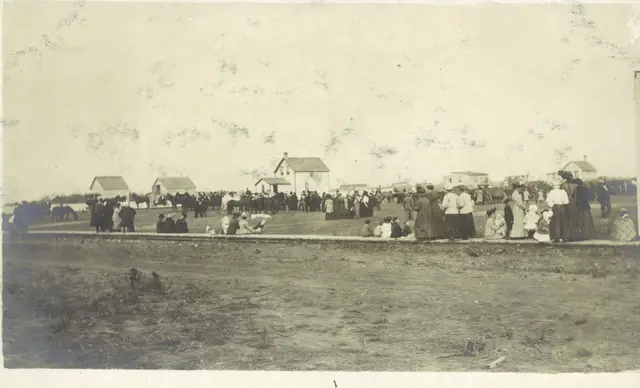 Crowd gathered at an event on the prairie